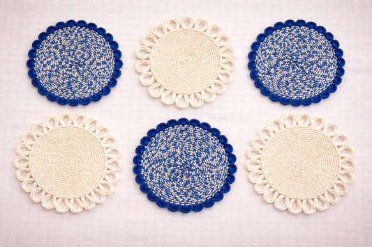 Capri Coastal table setting featuring a blue and white handwoven charger plate with elegant Mediterranean-inspired bohemian accessories in blue and white tones.