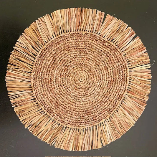 Top-down view of a Soleil Fringe cocoa brown raffia placemat, showing the radiant deep chocolate fringe border and soft handwoven texture for a neutral-themed table.