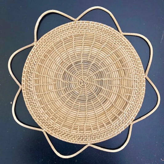 Close-up of a Natural Fleur Medallion handwoven rattan placemat with a floral petal edge, showcasing organic texture and artisanal craftsmanship for home decor.